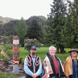 Totem_Pole_with_three_carvers_in_Hoonah.jpg